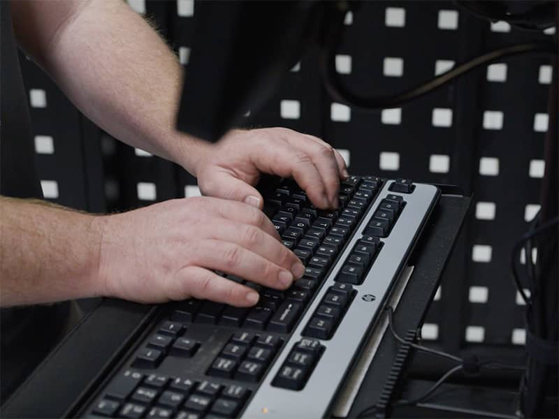A close up of a man typing on a keyboard.